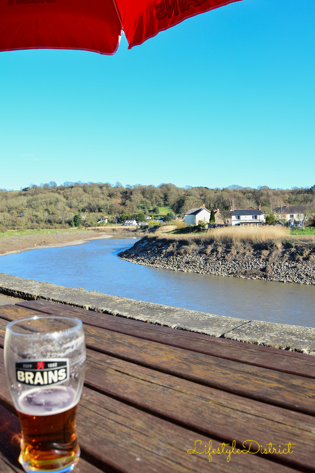 When in Wales: drinking a pint of Brains beer by the river Usk.
