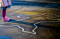child standing over bear chalk outline