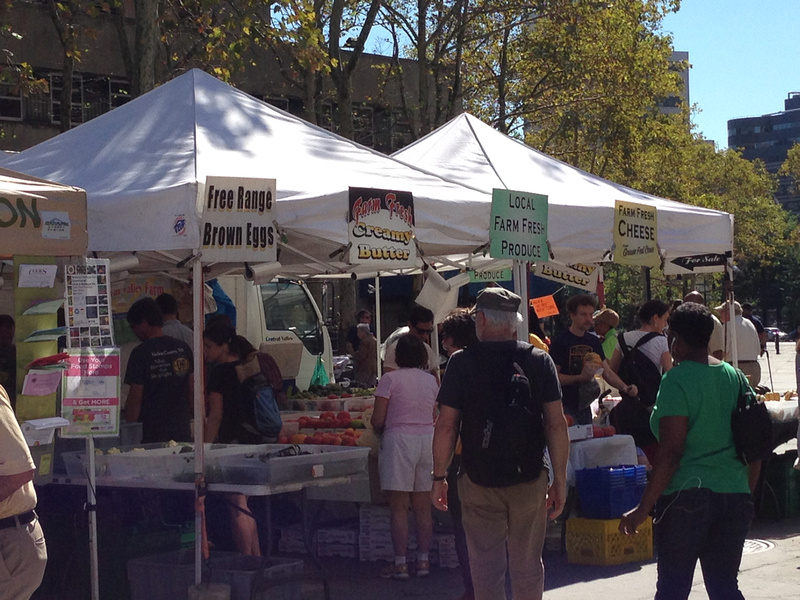 Crowds looking at cheese, fruit and vegetables at Brooklyn Borough Hall Greenmarket farmers market in New York City.